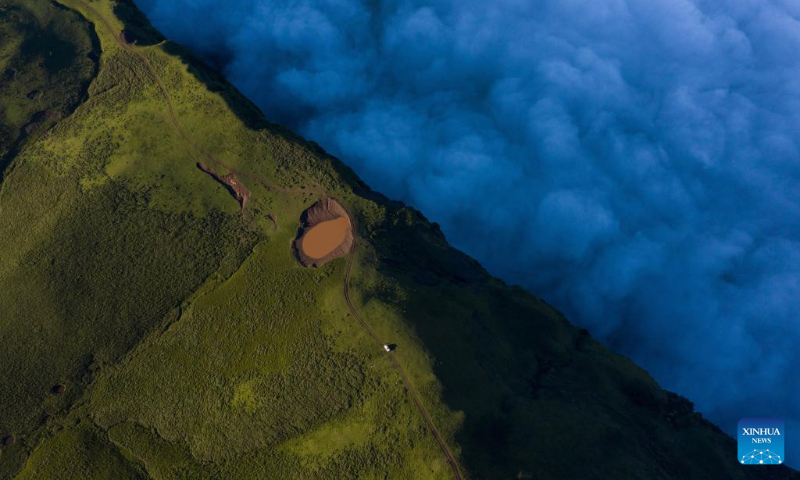 Aerial photo taken on July 7, 2022 shows clouds floating at sunrise in Mount Longtou in the border area between Leibo County and Meigu County, southwest China's Sichuan Province. The mountain reaches an altitude of 3,724 meters. (Xinhua/Jiang Hongjing)