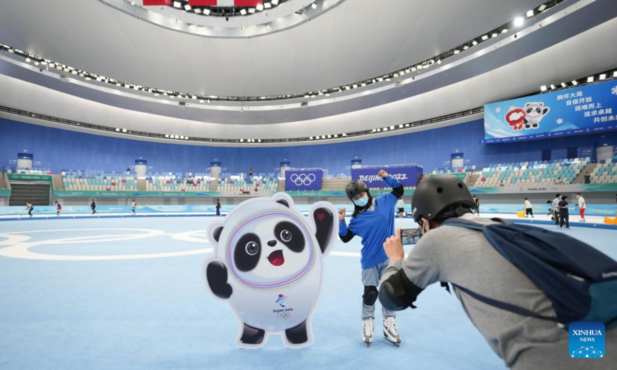 A tourist poses for photos at the National Speed Skating Oval in Beijing, capital of China, July 9, 2022. The National Speed Skating Oval, also known as the Ice Ribbon, opened to the public on Saturday. Photo:Xinhua