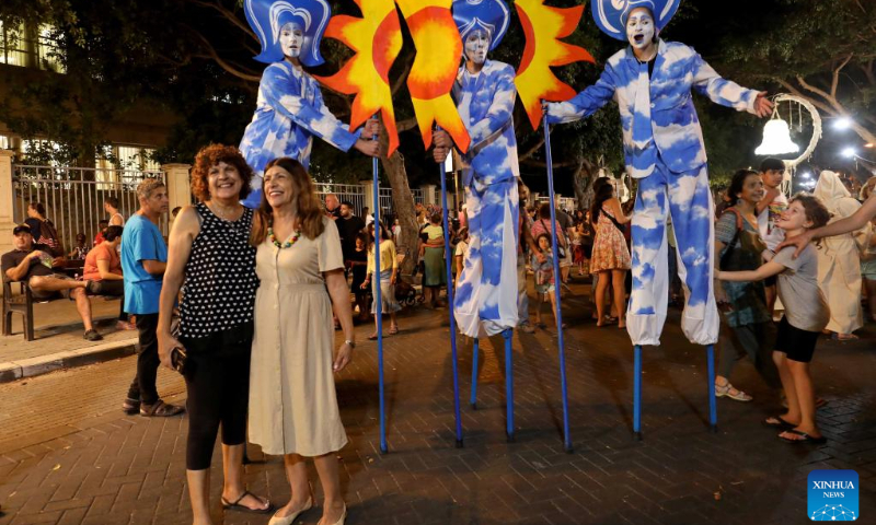 Visitors pose for photos with artists during the Rehovot International Live Statues Festival in Rehovot, Israel, on July 5, 2022. The festival is held from July 5 to 7 with more than 40 artists participating. (Photo by Gil Cohen Magen/Xinhua)