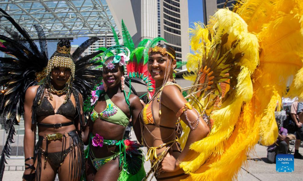 Dressed-up revelers pose for photos during the official launch ceremony of the 2022 Toronto Caribbean Carnival in Toronto, Canada, on July 7, 2022. As a spectacular display of Caribbean music, costumes and culture, the annual event is held here from July 7 to July 31. Photo:Xinhua