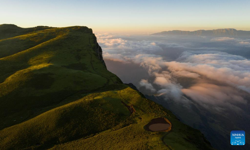 Aerial photo taken on July 7, 2022 shows clouds floating at sunrise in Mount Longtou in the border area between Leibo County and Meigu County, southwest China's Sichuan Province. The mountain reaches an altitude of 3,724 meters. (Xinhua/Jiang Hongjing)