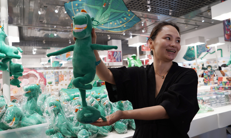 An employee of the Gansu Provincial Museum shows a plush toy of the ancient bronze horse statue 