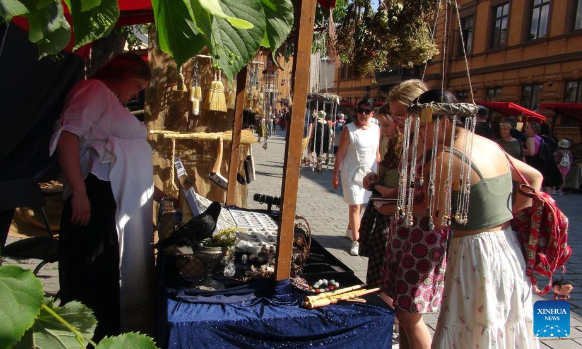 Tourists visit a stall at the annual Medieval Market in Turku, Finland, June 30, 2022. The annual Medieval Market, one of the largest historical events in Finland, kicked off on Thursday. Visitors enjoy a robust medieval atmosphere with stall owners and actors dressed in medieval style costumes at the market. Photo:Xinhua
