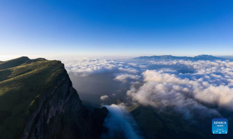 Aerial photo taken on July 7, 2022 shows clouds floating in Mount Longtou in the border area between Leibo County and Meigu County, southwest China's Sichuan Province. The mountain reaches an altitude of 3,724 meters. (Xinhua/Jiang Hongjing)