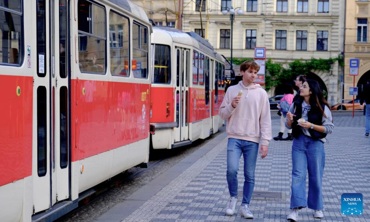 People walk past a tram at a station in Prague, capital of the Czech Republic, July 8, 2022. Photo:Xinhua