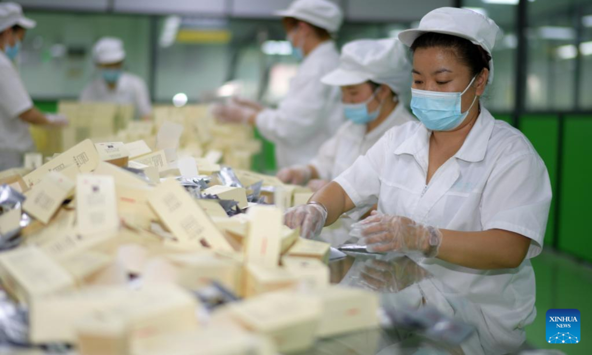 Workers pack tea products made of honeysuckle at a plant in Suiyang County, southwest China's Guizhou Province, July 1, 2022. The local government has been making efforts in developing industries related with honeysuckle, which has entered its harvest season lately. Photo:Xinhua