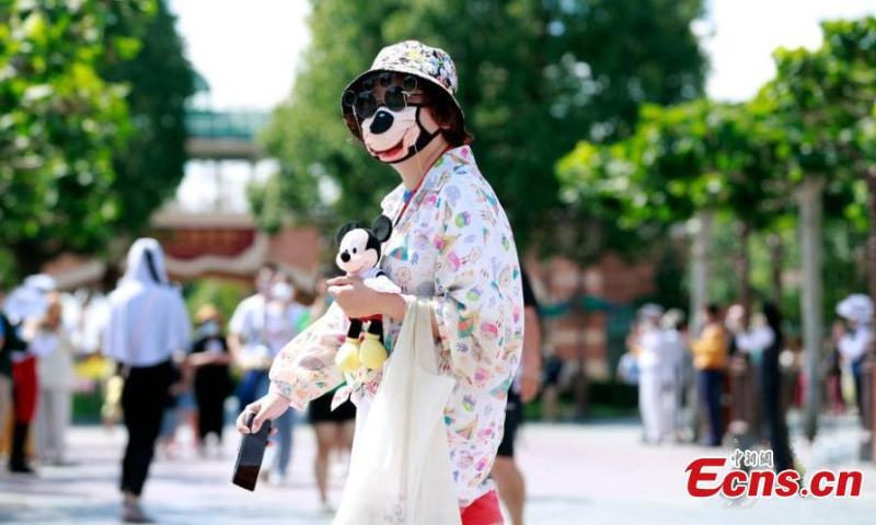 2022 年 6 月 30 日，上海迪士尼度假区重新开放时，一位戴着米老鼠主题面具的游客参观。（图片：中新社/唐彦军）
