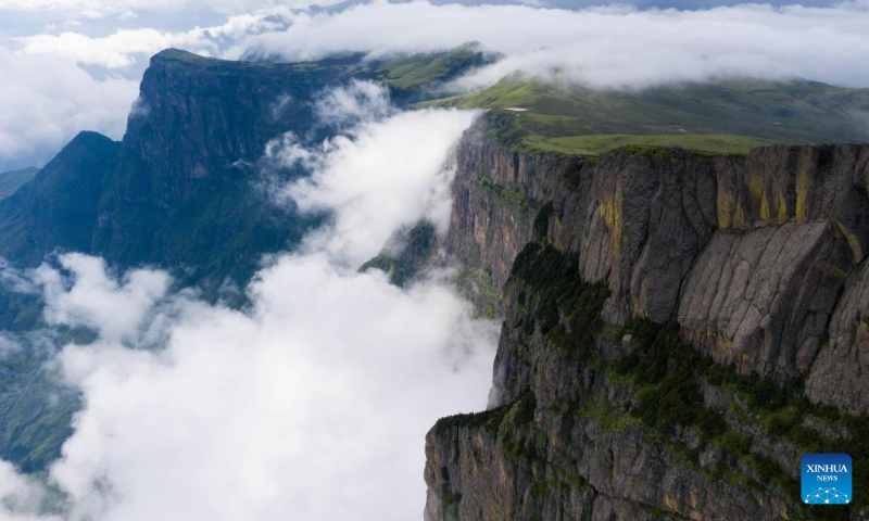 Aerial photo taken on July 6, 2022 shows clouds floating in Mount Longtou in the border area between Leibo County and Meigu County, southwest China's Sichuan Province. The mountain reaches an altitude of 3,724 meters. (Xinhua/Jiang Hongjing)