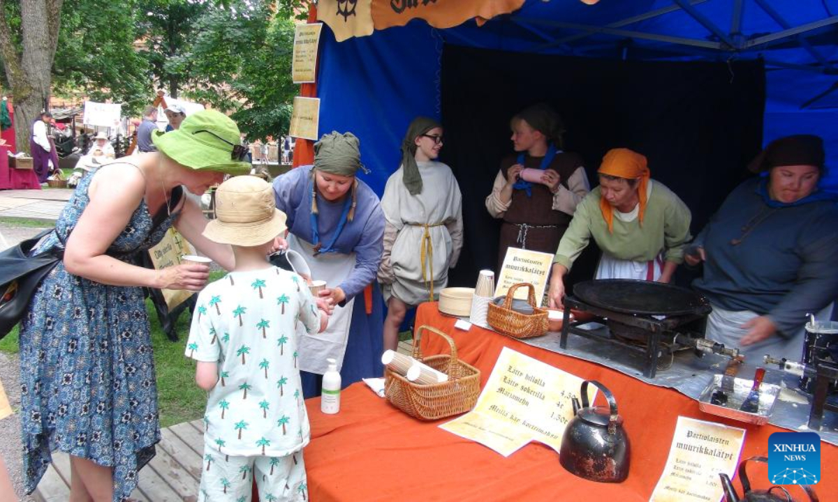 Tourists taste drinks at the annual Medieval Market in Turku, Finland, June 30, 2022. The annual Medieval Market, one of the largest historical events in Finland, kicked off on Thursday. Visitors enjoy a robust medieval atmosphere with stall owners and actors dressed in medieval style costumes at the market. Photo:Xinhua