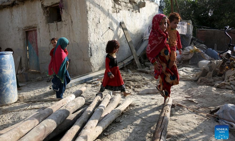 People walk past a house damaged in an earthquake in Khost province, Afghanistan, on June 26, 2022.Photo:Xinhua