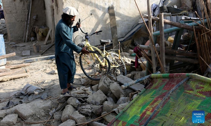 A man holds a bicycle in front of a house damaged in an earthquake in Khost province, Afghanistan, on June 26, 2022.Photo:Xinhua
