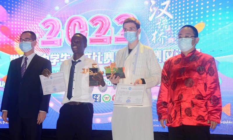 Chinese Bridge Chinese proficiency competition winners Noah Killeen (2nd R) and Moses Echoni (2nd L) pose for a group photo after receiving certificates and prizes during the Chinese Bridge Chinese proficiency competition for university and secondary students at the Confucius Institute of Makerere University in Kampala, Uganda, June 25, 2022.Photo:Xinhua