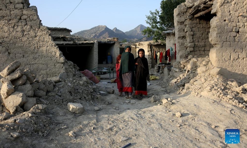 People stand beside buildings damaged in an earthquake in Khost province, Afghanistan, on June 26, 2022.Photo:Xinhua