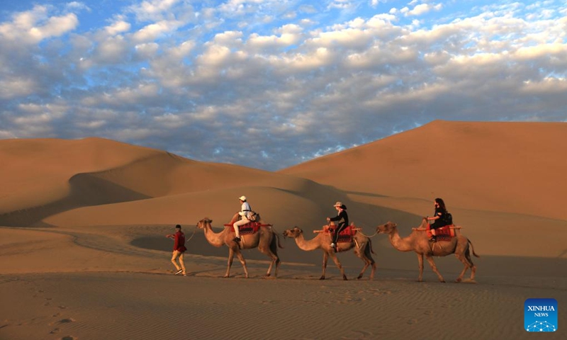 People visit Mingsha Mountain and Crescent Spring scenic spot in Dunhuang City, northwest China's Gansu Province, June 27, 2022.(Photo: Xinhua)