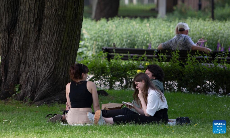 People sit in the shade on a hot day in Riga, Latvia, June 27, 2022. Meteorologists in Latvia issued a red warning for extreme heat on Monday as the mercury tops 30 degrees Celsius, a sharp rise in the Baltic country known for its mild pleasant summers.(Photo: Xinhua)