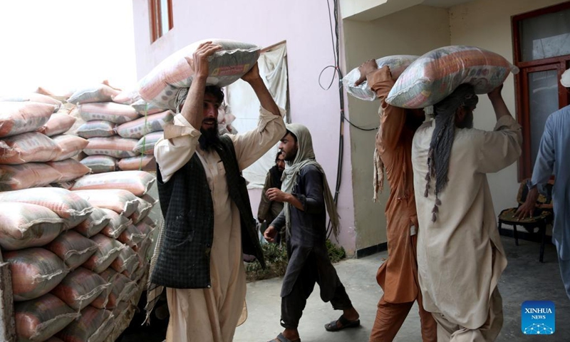 People receive food aid donated by a Chinese firm in Khost province, Afghanistan, June 26, 2022. The first batch of food aid donated by a Chinese firm has reached the earthquake-hit region in eastern Afghanistan, an Afghan disaster management official said on Monday.(Photo: Xinhua)