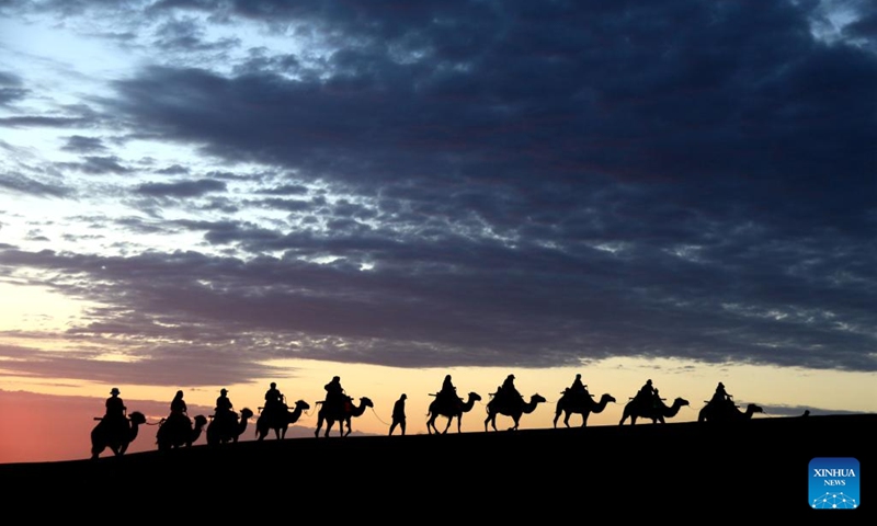 People visit Mingsha Mountain and Crescent Spring scenic spot in Dunhuang City, northwest China's Gansu Province, June 27, 2022.(Photo: Xinhua)