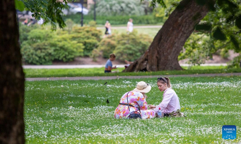 People sit in the shade on a hot day in Riga, Latvia, June 27, 2022. Meteorologists in Latvia issued a red warning for extreme heat on Monday as the mercury tops 30 degrees Celsius, a sharp rise in the Baltic country known for its mild pleasant summers.(Photo: Xinhua)