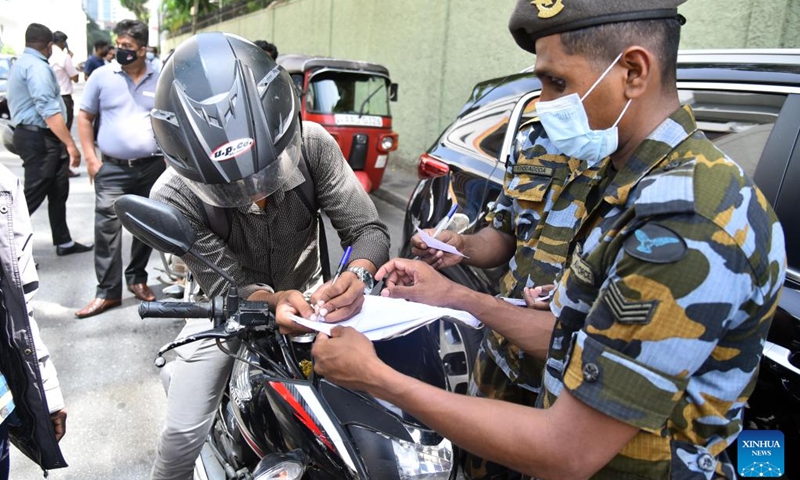 A military personnel issues tokens for consumers who queue up at a fuel station in Colombo, Sri Lanka, on June 27, 2022. Fuel filling stations across the country started issuing tokens for consumers from Monday as only limited stocks of fuel were available.(Photo: Xinhua)