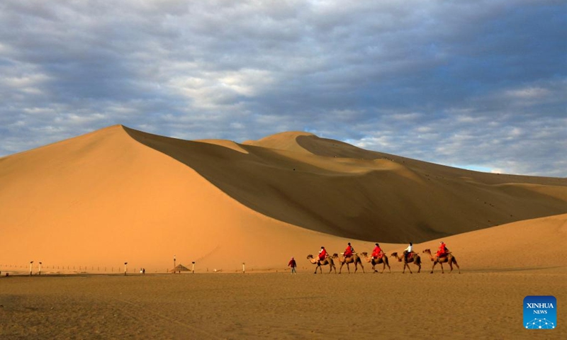 People visit Mingsha Mountain and Crescent Spring scenic spot in Dunhuang City, northwest China's Gansu Province, June 27, 2022.(Photo: Xinhua)