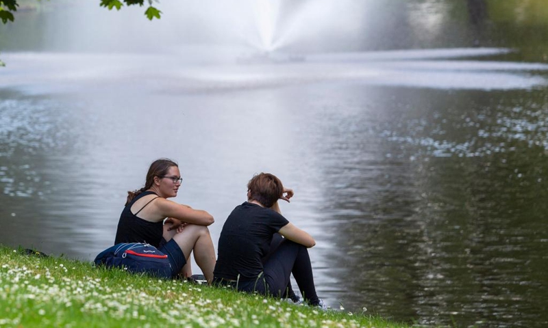 People sit in the shade by the water on a hot day in Riga, Latvia, June 27, 2022. Meteorologists in Latvia issued a red warning for extreme heat on Monday as the mercury tops 30 degrees Celsius, a sharp rise in the Baltic country known for its mild pleasant summers.(Photo: Xinhua)