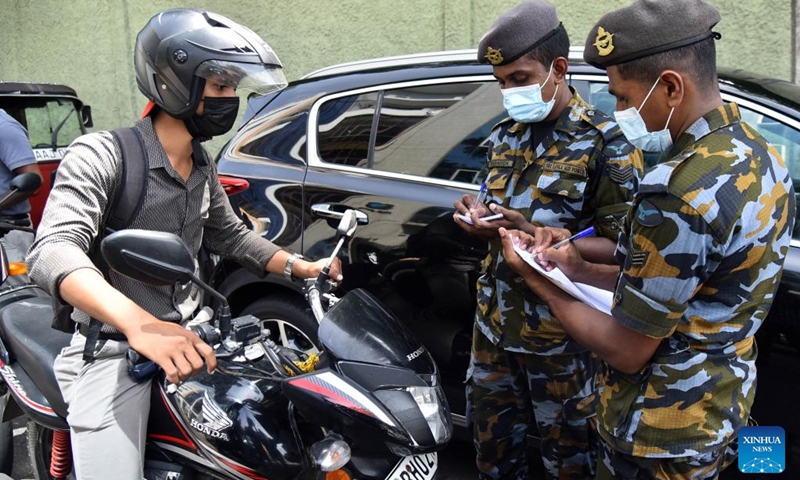 Military personnel issue tokens for a consumer who queues up at a fuel station in Colombo, Sri Lanka, on June 27, 2022. Fuel filling stations across the country started issuing tokens for consumers from Monday as only limited stocks of fuel were available.(Photo: Xinhua)