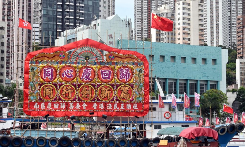 A fishing vessel with China's national flag and the Hong Kong Special Administrative Region (HKSAR) flag and flower plaque is seen in Hong Kong, south China, June 30, 2022. July 1 is the celebration day for the 25th anniversary of Hong Kong's return to the motherland.(Photo: Xinhua)