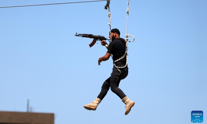 A member of the Palestinian Hamas security forces shows his skills as he takes part in a military graduation ceremony in the southern Gaza Strip city of Khan Younis, on June 30, 2022.(Photo: Xinhua)