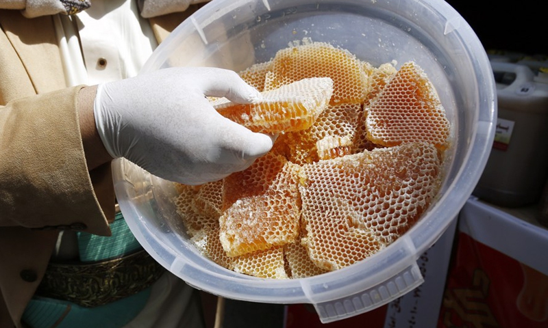 A seller displays his honey products at a honey festival in Sanaa, capital of Yemen, on June 30, 2022.(Photo: Xinhua)