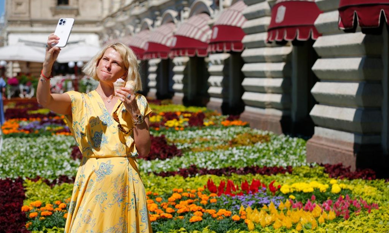 A woman takes a selfie during an annual flower festival outside the GUM department store near Red Square in central Moscow, Russia, on July 1, 2022.(Photo: Xinhua)