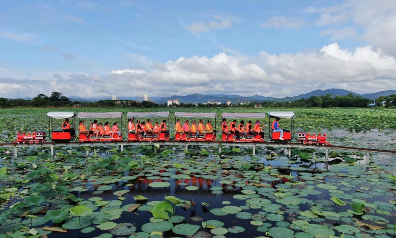 Visitors take sightseeing mini trains to enjoy lotus flowers at Longde Lake in Jinghong City of Xishuangbanna Dai Autonomous Prefecture, southwest China's Yunnan Province, July 2, 2022.Photo:Xinhua