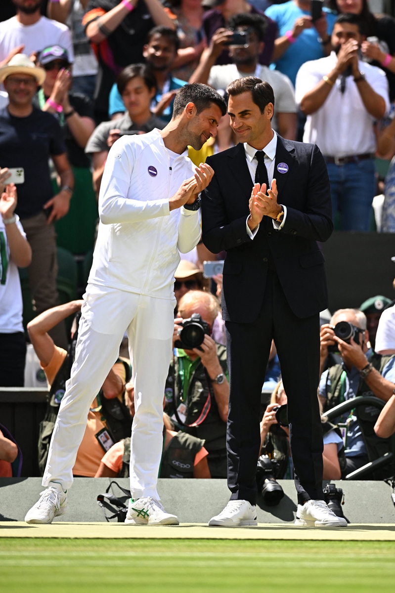 Novak Djokovic (left) and Roger Federer communicate during the centenary ceremony held on Center Court at Wimbledon in London, on July 3, 2022. Photo: VCG