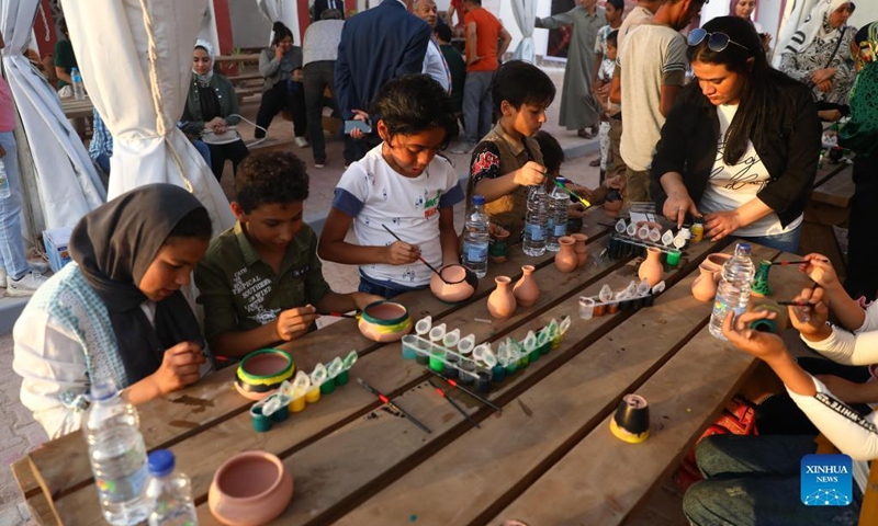 People color pottery wares during a pottery exhibition at Fustat Pottery Village in Cairo, Egypt, July 3, 2022. A three-day pottery exhibition opened on Sunday at the Fustat Pottery Village, with the aim of promoting traditional Egyptian pottery culture and reviving pottery industry.(Photo: Xinhua)