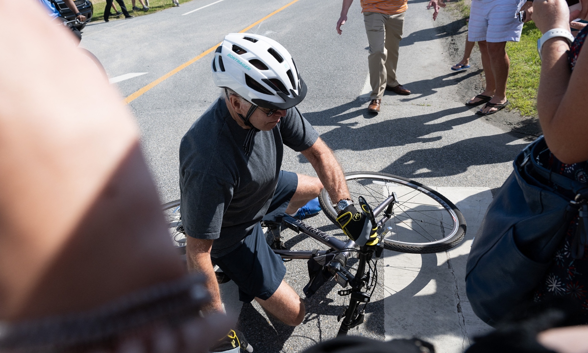 US President Joe Biden falls off his bicycle as he approaches well-wishers following a bike ride at Gordon's Pond State Park in Rehoboth Beach, Delaware, on June 18, 2022. Photo: AFP