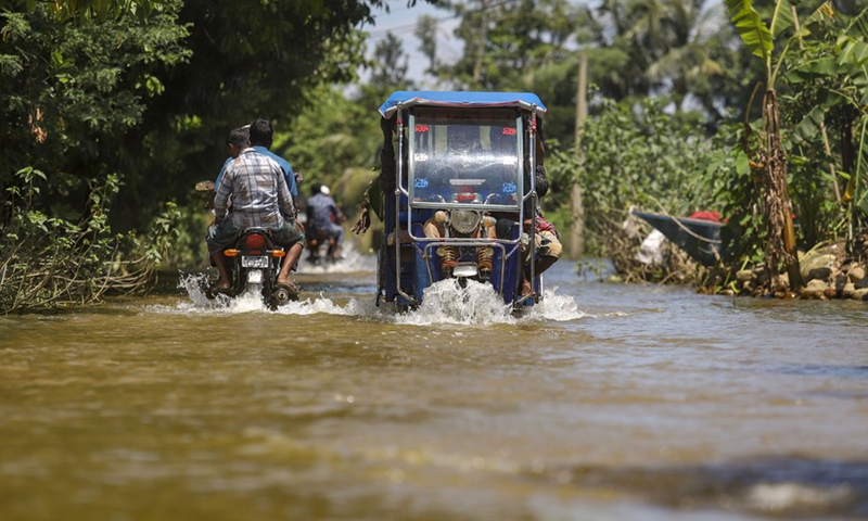 A rickshaw and motorcycles move through a flooded road in Sunamganj, Bangladesh, on July 3, 2022.(Photo: Xinhua)