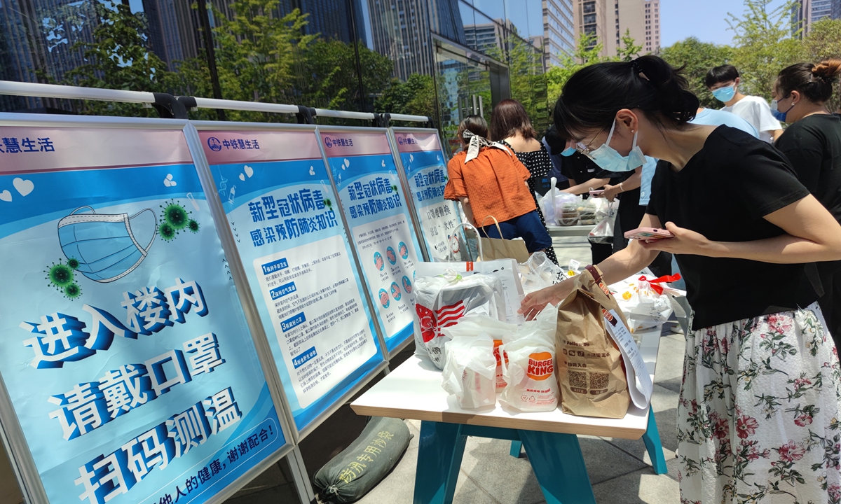 Residents fetch take-out food outside an office building in Xi'an, Northwest China's Shaanxi Province, the first day that the city conducts seven-day temporary epidemic prevention control measures in some public areas. Photo: VCG