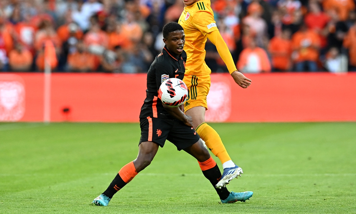 The Netherlands' defender Tyrell Malacia (left) fights for the ball during the UEFA Nations League - League A Group 4 soccer match between the Netherlands and Wales at the Feyenoord 