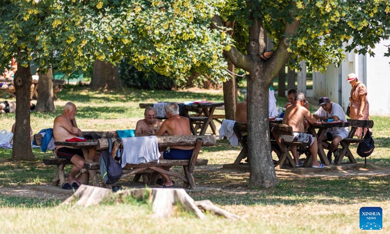 People spend time in the shade at a park in Belgrade, Serbia, on July 5, 2022. Serbia witnessed hot weather recently. (Photo: Xinhua)