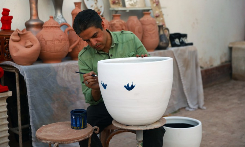 A craftsman colors pottery ware during a pottery exhibition at Fustat Pottery Village in Cairo, Egypt, July 3, 2022. (Photo: Xinhua)