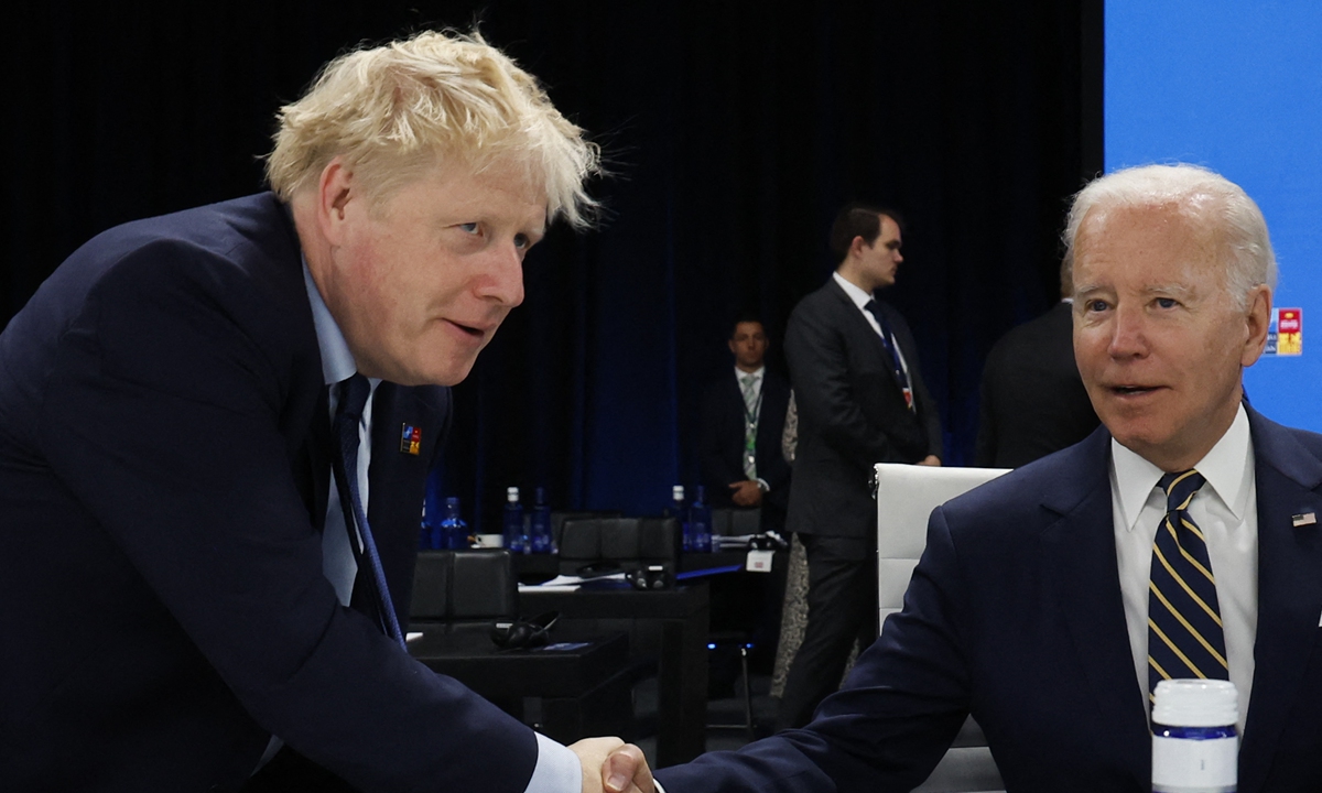US President Joe Biden and Britain's Prime Minister Boris Johnson shake hands ahead of a meeting of The North Atlantic Council during the NATO summit in Madrid on June 30, 2022. Photo: AFP