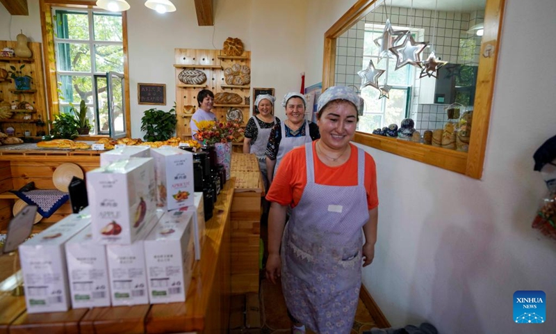 Feng Xiaoli (1st L), owner of the Liuba Bakery, and her employees get off work at the bakery in Yining City, northwest China's Xinjiang Uygur Autonomous Region, June 23, 2022. Located at a commercial area of Liuxing Street in Yining City, Liuba Bakery is well known for its quality bread. Besides, it has provided job opportunities for local women to increase their income.(Photo: Xinhua)