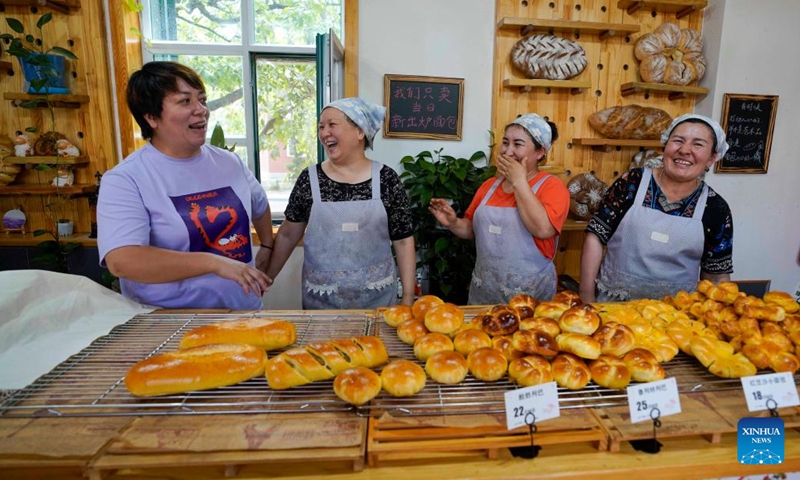 Feng Xiaoli (1st L), owner of the Liuba Bakery, chats with her employees at the bakery in Yining City, northwest China's Xinjiang Uygur Autonomous Region, June 23, 2022. Located at a commercial area of Liuxing Street in Yining City, Liuba Bakery is well known for its quality bread. Besides, it has provided job opportunities for local women to increase their income.(Photo: Xinhua)