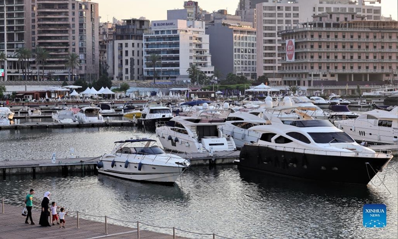 People look at yachts in a marina in Beirut, Lebanon, on July 6, 2022. In the 2000s, Lebanon's boat industry saw glamorous times. However, the scene is completely different today. The Beirut Marina is half empty, let alone the other 14 marinas spreading across the country.(Photo: Xinhua)