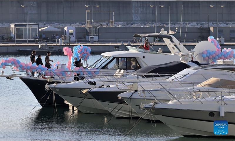 People decorate a private yacht in a marina in Beirut, Lebanon, on July 7, 2022. In the 2000s, Lebanon's boat industry saw glamorous times. However, the scene is completely different today. The Beirut Marina is half empty, let alone the other 14 marinas spreading across the country.(Photo: Xinhua)