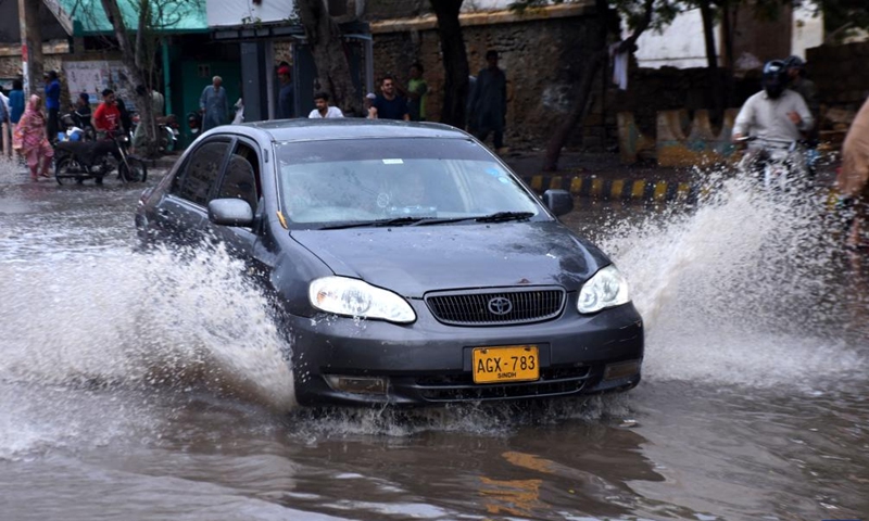 A car moves on a flooded road after heavy rains in southern Pakistani port city of Karachi on July 9, 2022.Photo:Xinhua