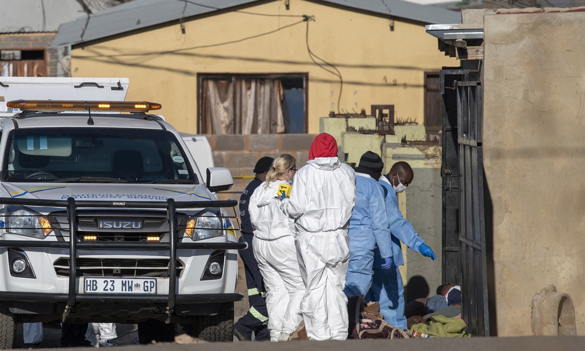 Members of the South African Police Service and forensic pathology service inspect the scene of a mass shooting in Soweto, South Africa, on July 10, 2022. Nineteen people were killed during a shootout in a bar in Soweto, police said. Photo: AFP