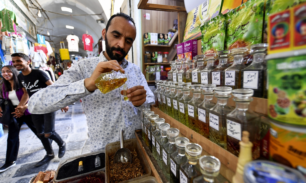 Tunisian perfumer Zouhaier Ben Abdallah blends jasmine extracts at his bazaar shop in the old Medina of Tunis, on May 21, 2022. Photo: AFP