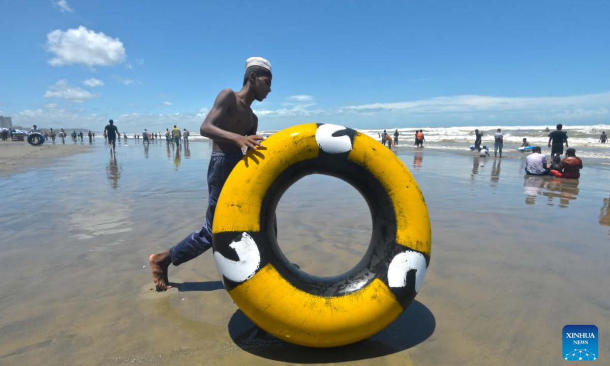 A man moves a make-shift life buoy at a beach during Eid al-Adha holiday in Cox's Bazar, Bangladesh, July 12, 2022. Photo:Xinhua