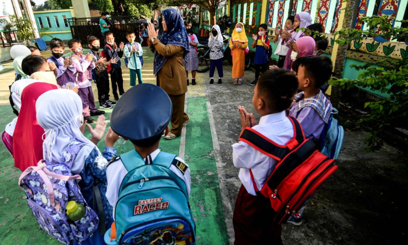 A faculty member organizes a game for the students during the first-day orientation of school year 2022-2023 at Jombang elementary school in South Tangerang of Banten Province, Indonesia, July 11, 2022. (Xinhua/Agung Kuncahya B.)