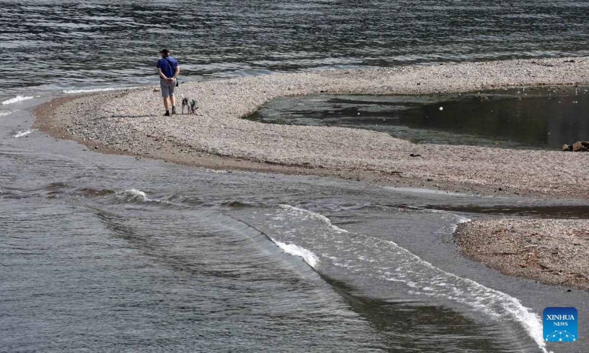 A man walks a dog at Lake Como in Como, Lombardy region, Italy, on July 13, 2022. Photo:Xinhua